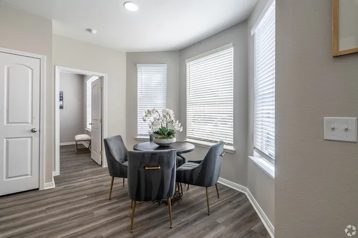 Light-filled dining space with round table and chairs at Towne West Apartments