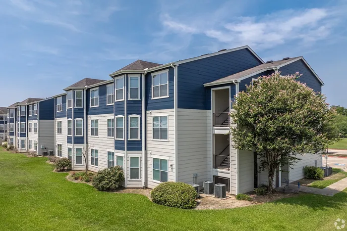 Modern three-story apartment building with navy and white exterior at Towne West Apartments in Houston, TX