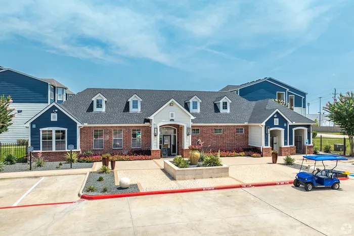 Leasing office and clubhouse building with landscaped entrance at Towne West Apartments in Houston, TX