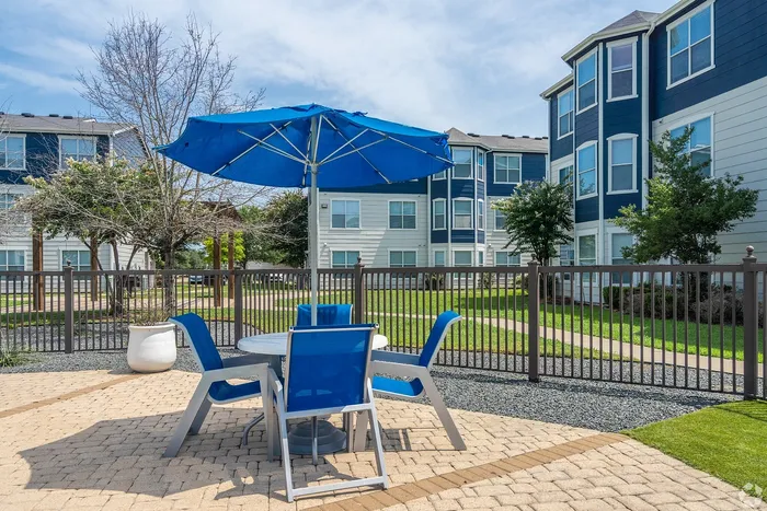 Outdoor patio area with umbrella-covered seating at Towne West Apartments