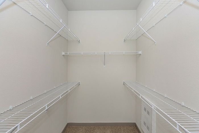 Walk-in closet with custom shelving and ample hanging space at Cityscape Apartments