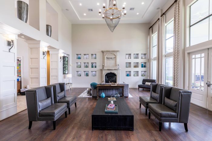 room with tall ceilings, hardwood floors, and cozy seating