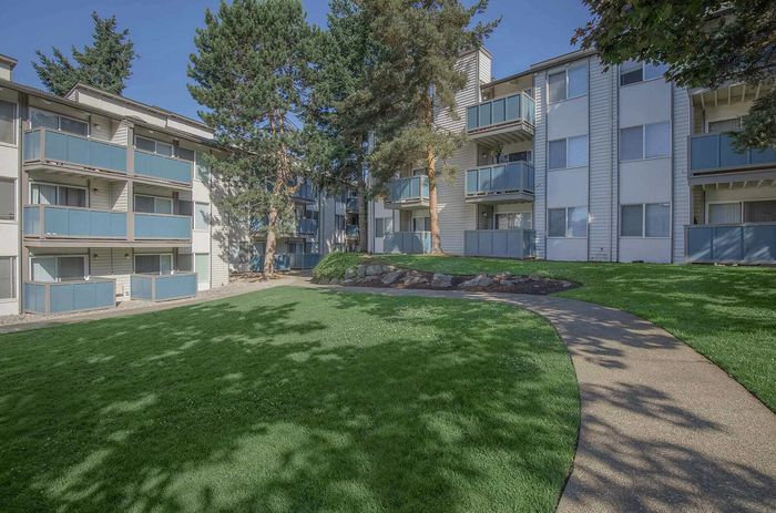 Foster Creek Apartments landscaped front entrance with trees and green lawn