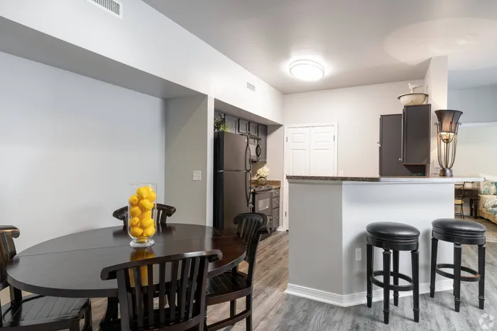 Cozy dining area with elegant table settings and a view into the modern kitchen at Lifestyles Hueco Estates in El Paso, TX.