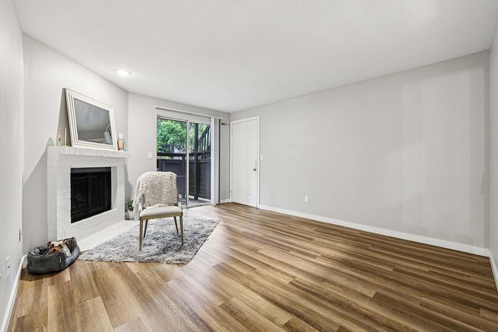 spacious living area with wood inspired fooring and wood burning fireplace at The Ardent