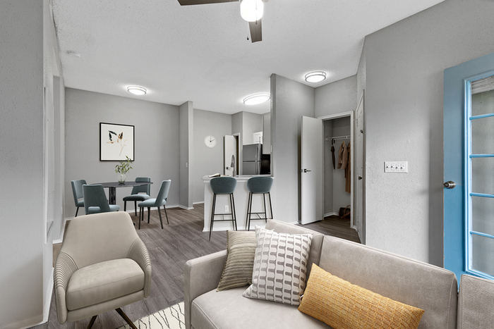 Living space with wood floors, ceiling fan,  and kitchen bar