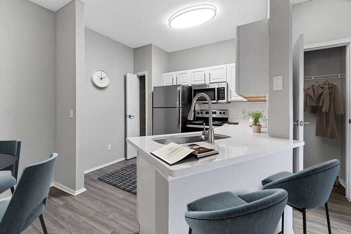 Kitchen with vinyl floors, stainless-steel appliances, white quartz countertop