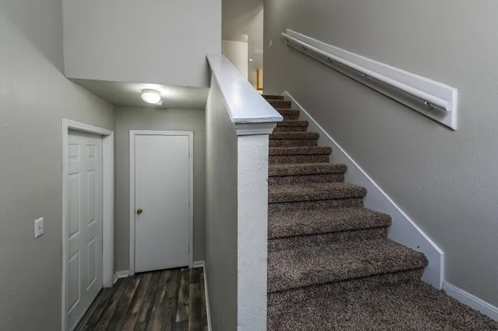 a plush carpeted staircase leading to the second floor of an apartment home at Rancho de Luna Apartments in Robstown, TX