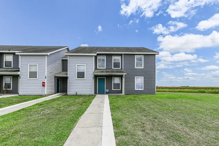 apartment homes surrounded by sidewalks and lush green grass