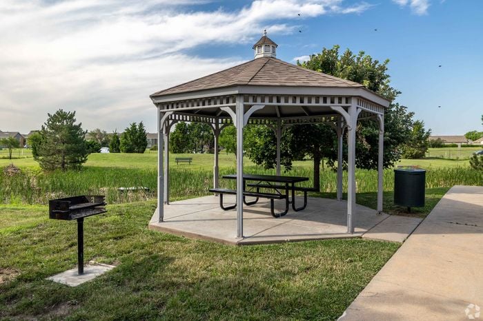 White outdoor gazebo with picnic table and purple planters at Inwood Crossings Apartments in Wichita, Kansas.