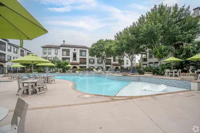 Resort-style swimming pool with cascading water features and lounge seating at Amalfi at Tuscan Lakes in League City, TX.