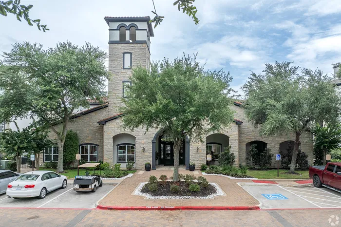 Clubhouse exterior with stone façade and landscaped entryway at Amalfi at Tuscan Lakes in League City, TX.