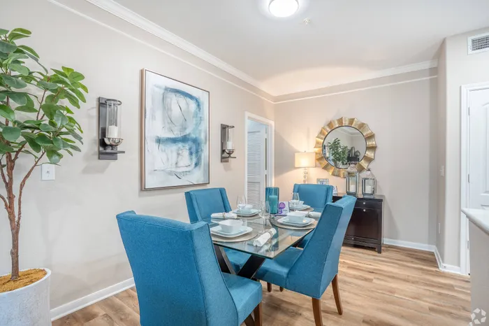 Open-concept dining area with elegant blue chairs, adjacent to a modern kitchen at Amalfi at Tuscan Lakes in League City, TX.