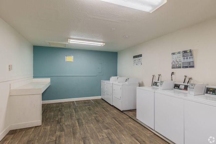 Modern laundry room with multiple washers and dryers at Fox Pointe Apartments in Portland, OR