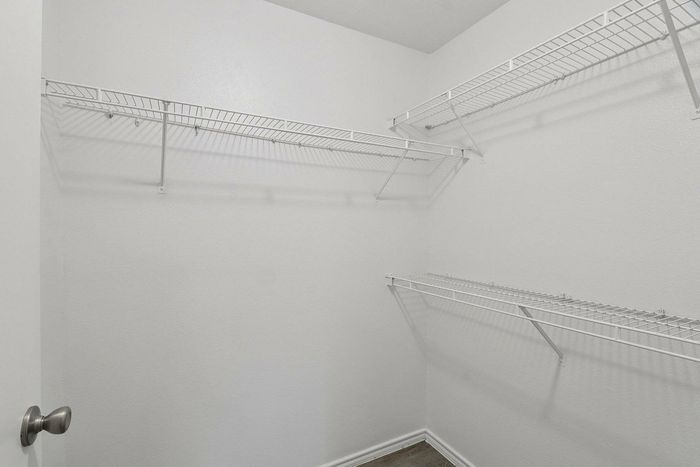 Walk-in closet with built-in shelving and hanging space in Avonmora apartment, Austin TX
