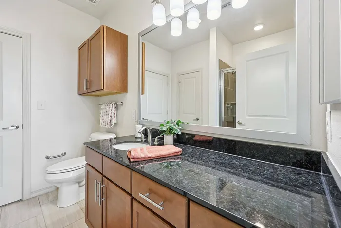 Stylish apartment bathroom with granite vanity in Plano, TX
