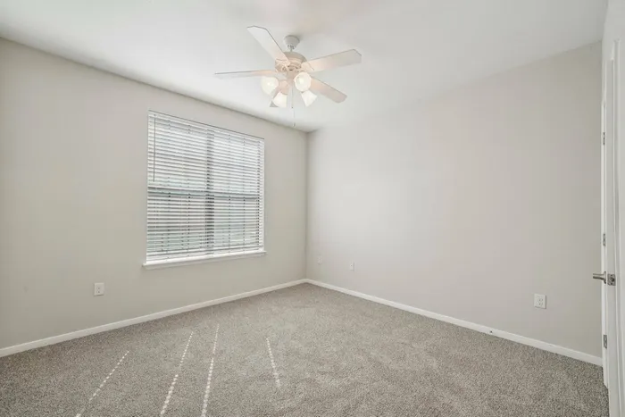 Large bedroom with plush carpeting at Walnut Grove in Seguin, TX