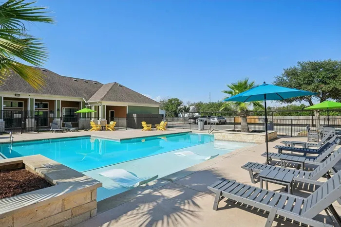 Sparkling resort-style pool with beach entry and sundeck at Walnut Grove Apartments in Seguin, TX