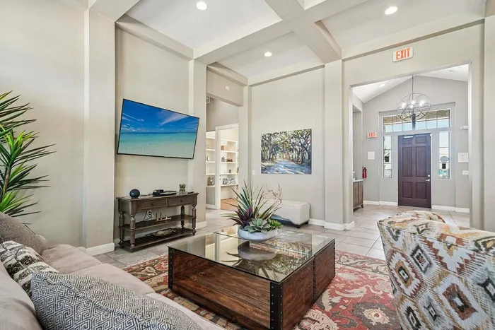 Modern indoor seating area with wall-mounted TV and decorative coffee table at Walnut Grove, Seguin, TX