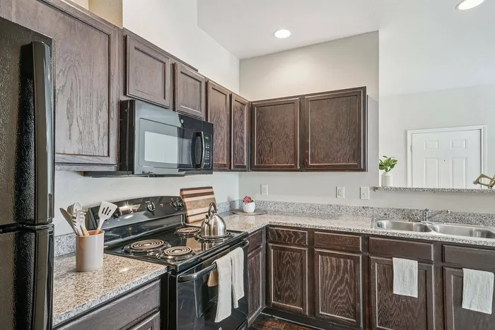 Bright kitchen with granite countertops and large windows at Walnut Grove Seguin