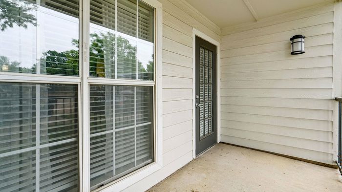 Private balcony with scenic views at Oak Forest Apartments in Lewisville, TX