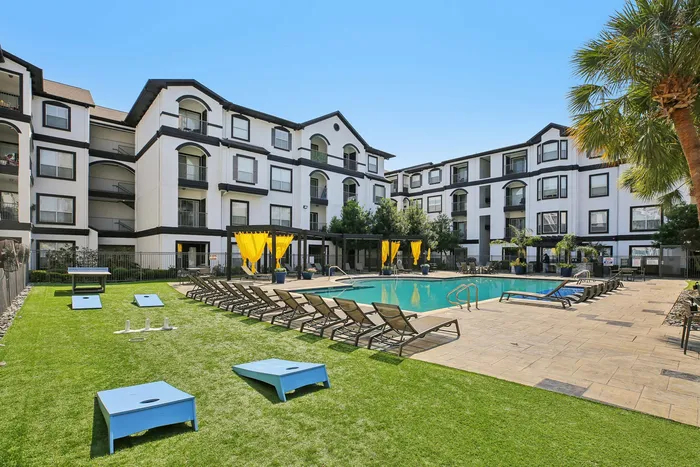 Outdoor resort-style swimming pool with lounge chairs at Providence Uptown, Houston