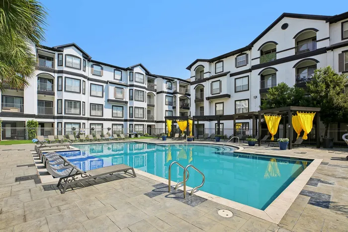 Luxury pool area with tanning deck at Providence Uptown apartments in Houston