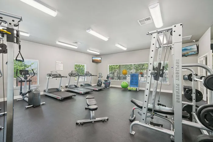 Modern fitness center with free weights at Arroyo Seco Villas in San Antonio, TX