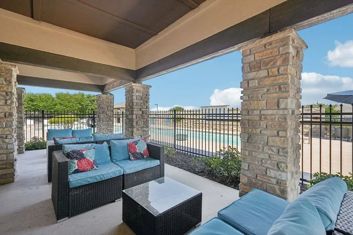 Poolside sitting area with lounge chairs at Arroyo Seco Villas in San Antonio, TX