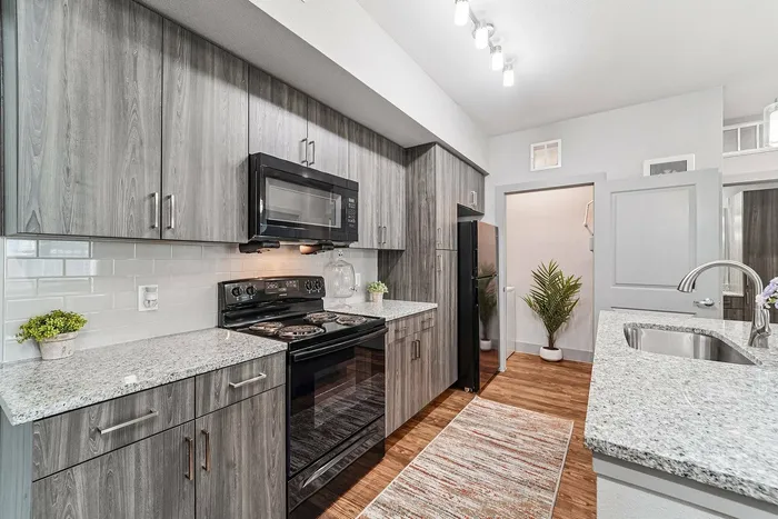 Modern all-electric kitchen with sleek appliances at The Broadway in Houston, TX