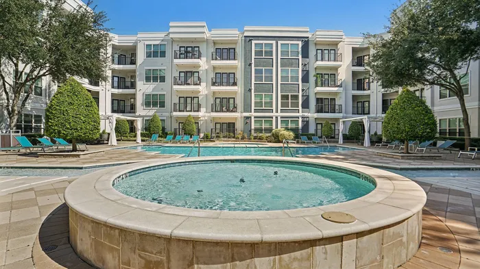 Resort-style swimming pool surrounded by lounge chairs at Addison Keller Springs in Addison, Texas