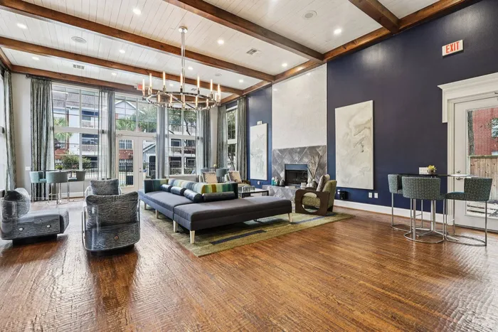 stunning clubhouse with seating, hardwood floors, large windows, and a fireplace