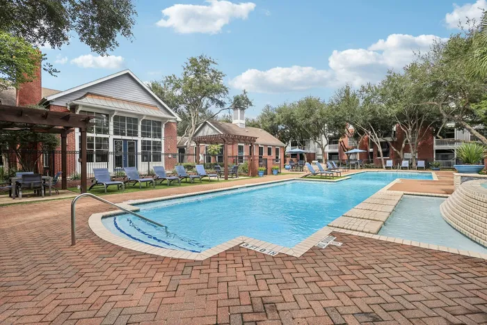 view of sparkling swimming pool, poolside lounge seating, and a clean manicured lawn