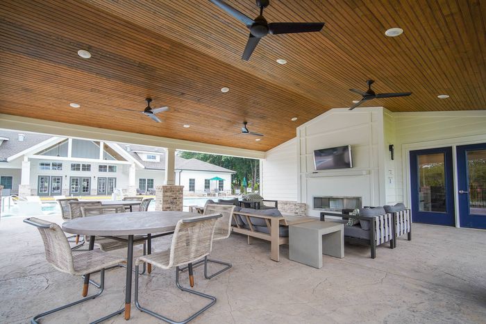 outdoor lounge with fireplace beside the pool