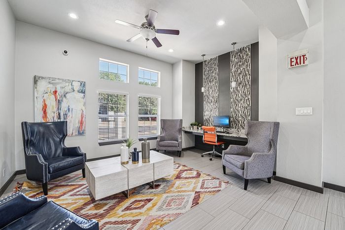 Modern leasing office with decor, comfortable seating, and large windows in the Avila apartment community.
