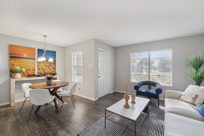 Spacious open-concept living and dining area with elegant furnishings, stylish accents, and warm natural light in a Waco, TX apartment.