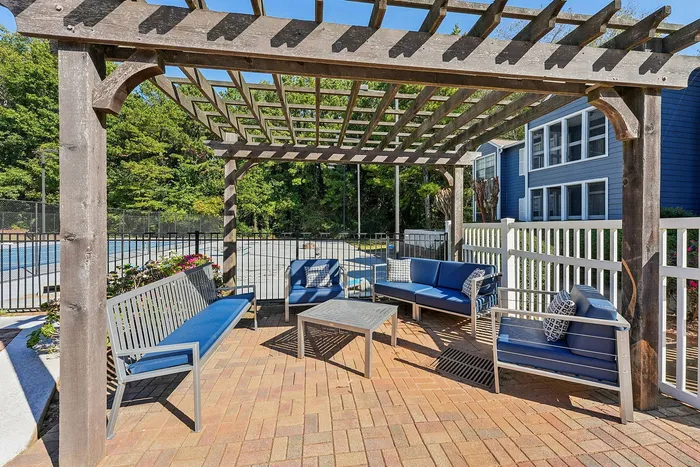 BBQ and picnic tables under shade trees at Avenues of Kennesaw in Kennesaw, GA