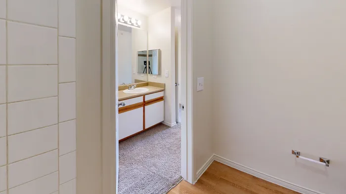 Bathroom featuring a clean vanity, large mirror, and bright lighting at Willowbend Apartments in San Antonio, TX.