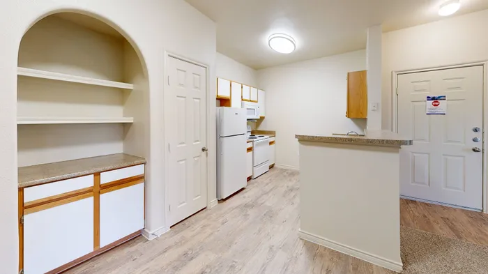 Spacious kitchen with white appliances, double sink, and wood-accented cabinetry at Willowbend Apartments in San Antonio, TX.