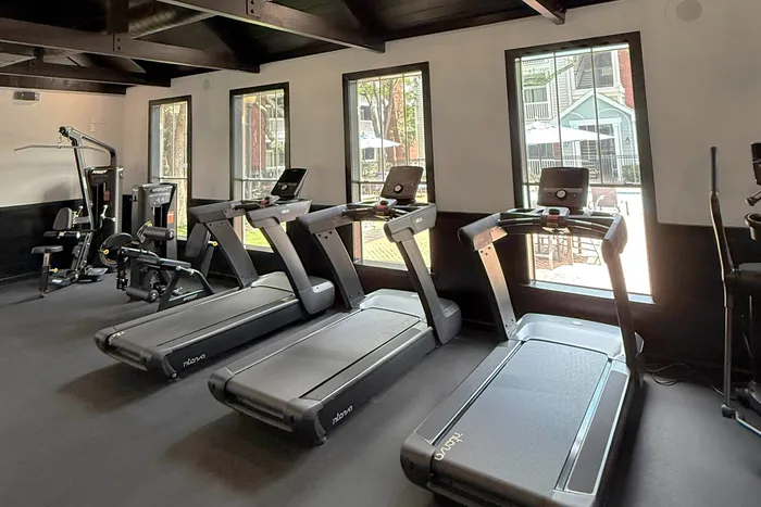 fitness center filled with bright lighting, exercise equipment, and weights