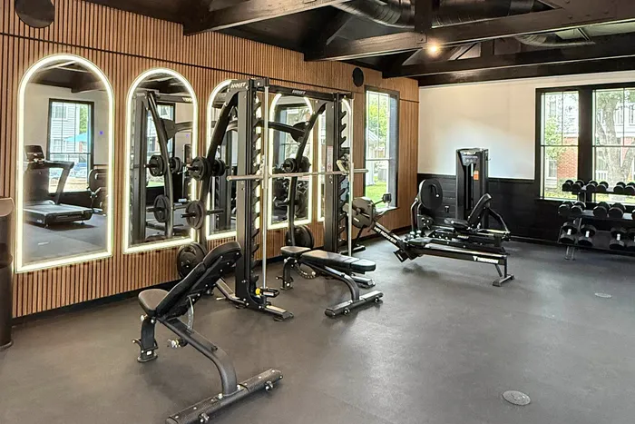fitness center filled with bright lighting, exercise equipment, and weights