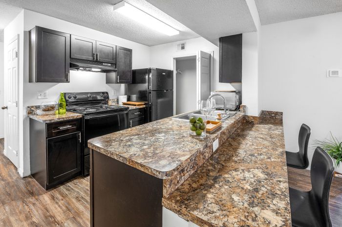 classic style kitchen with wood cabinets and black appliances