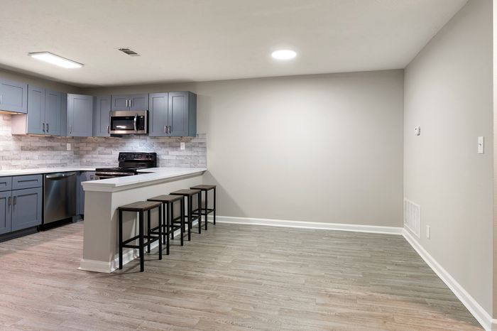 kitchen and breakfast bar open to living space