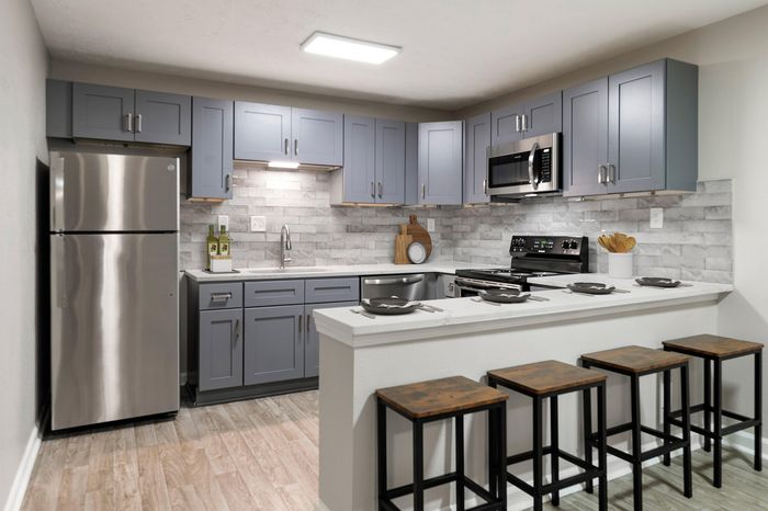 Large kitchen with stainless steel appliances, tile backsplash, and breakfast bar
