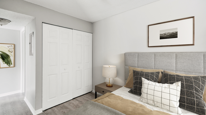 Hard wood floor, queen-size bedding,, end table, table lamp, wall art, sliding closet doors