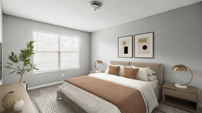 Carpeted bedroom, hard wood style flooring, standing decorative plant, queen-size bedding with fabric framing, wall art, end table with table lamp