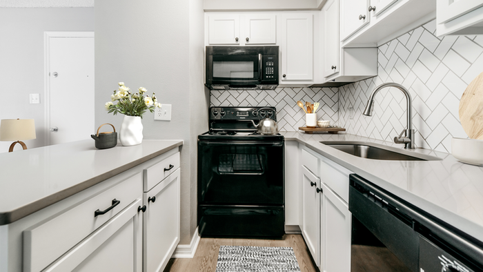 Kitchen with hard wood style flooring, black kitchen appliances, undermount sink with gooseneck faucet