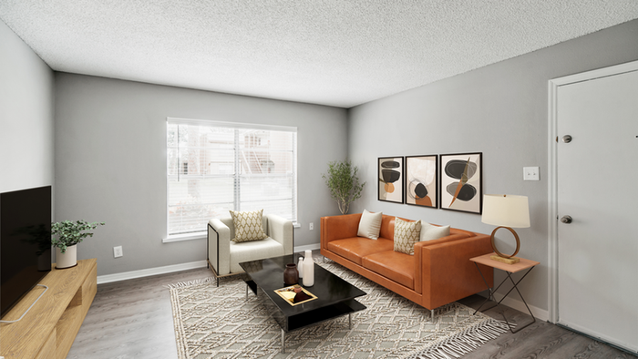 Livingroom with hardwood floor cream rug, black coffee table, orange leather couch, flat screen TV, wall  art, large center window, cream chair