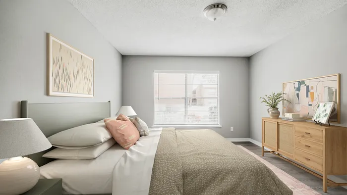 Bedroom with wooden dresser, queen-size bed, large center window, table lamp