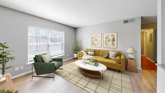 Living room hardwood style flooring with green chair, yellow couch, wide center window